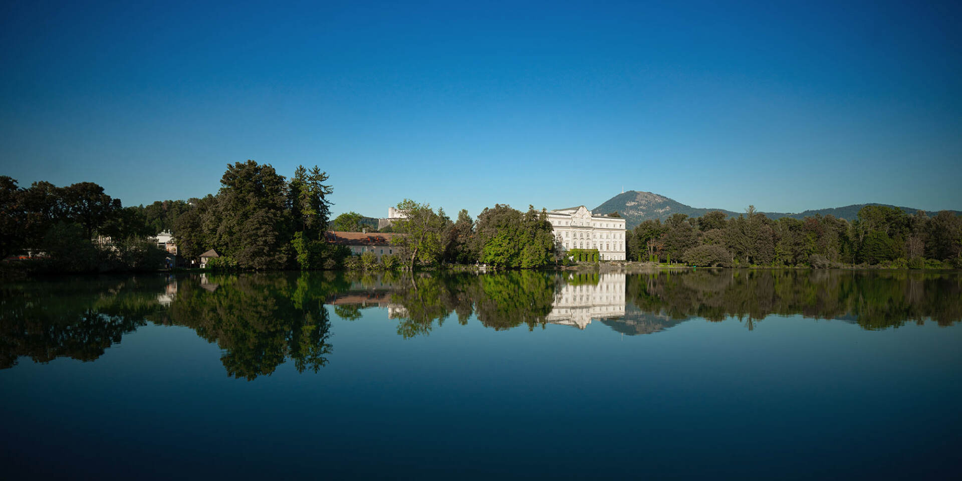 Leopoldskron pond and behind it Leopoldskron Palace in summer on Sound of Music Tour by Salzburg Panorama Tours