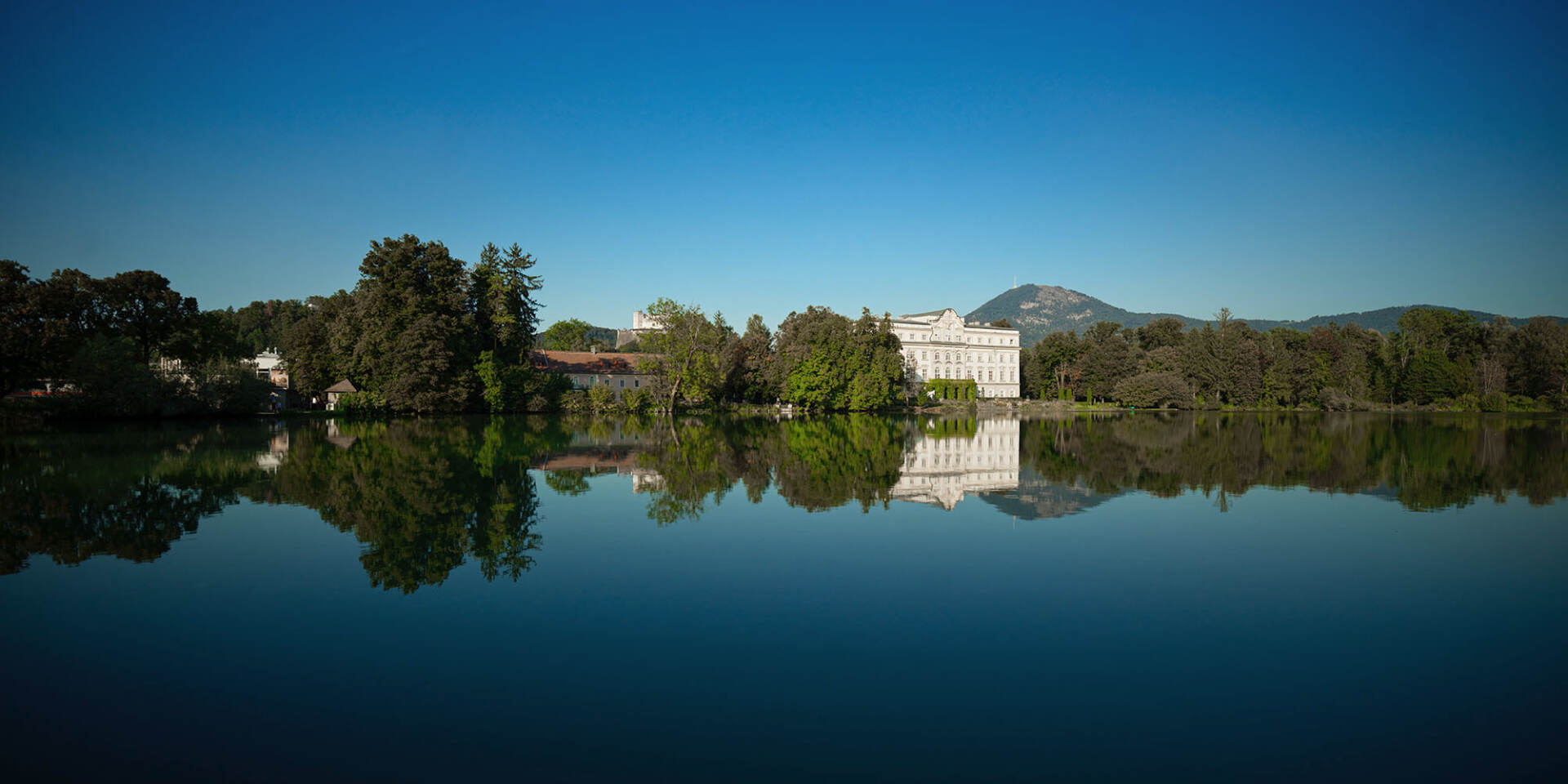 Leopoldskron pond and behind it Leopoldskron Palace in summer on Sound of Music Tour by Salzburg Panorama Tours