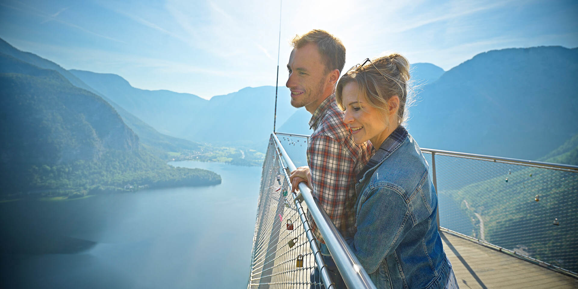 Hallstatt - Paar steht am Skywalk Welterbeblick und schaut auf den Hallstätter See und die umliegenden Berge - Hallstatt Tour mit Salzburg Panorama Tours