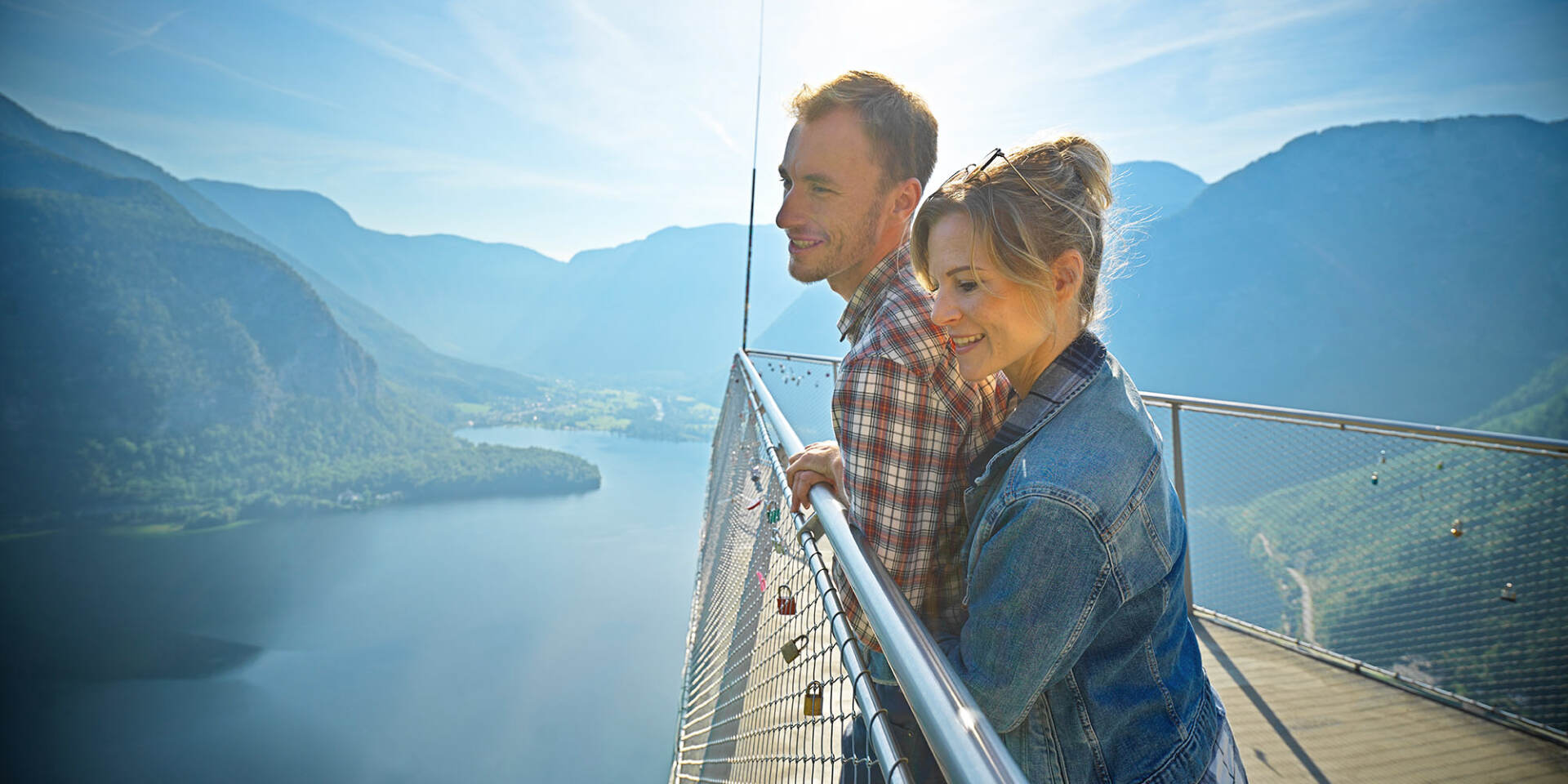 Hallstatt - Paar steht am Skywalk Welterbeblick und schaut auf den Hallstätter See und die umliegenden Berge - Hallstatt Tour mit Salzburg Panorama Tours