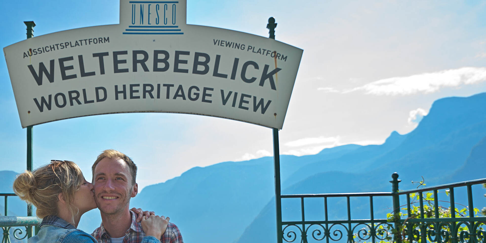 Hallstatt - Couple in front of sign World Heritage View - Hallstatt Tour with Salzburg Panorama Tours