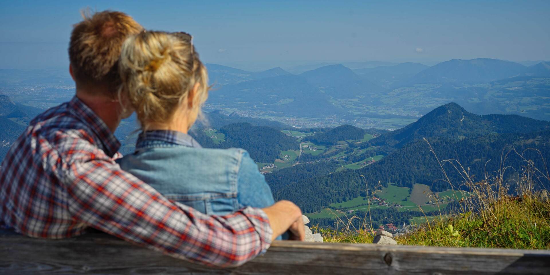 Kehlsteinhaus Berchtesgaden - Paar sitzt auf Bank und genießt Ausblick über die Bayerischen Alpen - Kehlsteinhaus Tour von Salzburg Panorama Tours